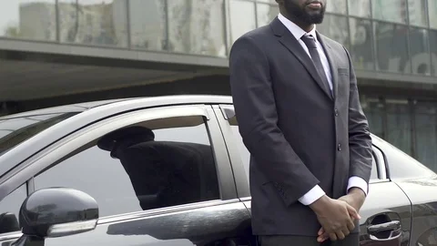 Private driver and bodyguard standing near car waiting for rich vip client 库存影片 82044610