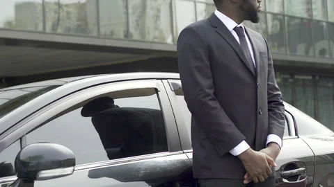 Private driver and bodyguard standing near car waiting for rich vip client Stock Footage 243286555