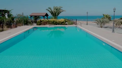 Private empty pool, with palm trees and sea views. Pool on the background Stock Footage 130601462