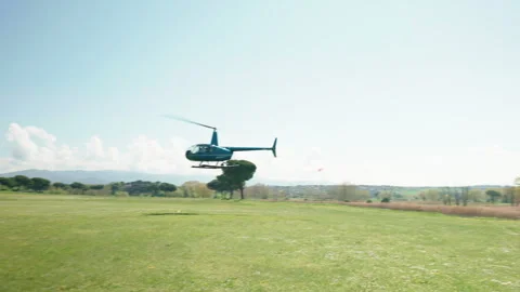 Private helicopter with rotating blades hovering in air above the landing pad in Vídeos de archivo 263918767