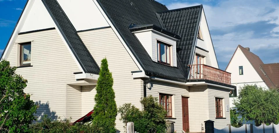 A private house of two floors with triangular roof and an area near the house Stock Photos