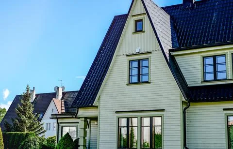 A private house of two floors with triangular roof and an area near the house Stock Photos