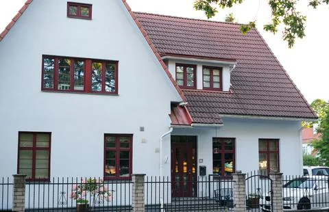 A private house of two floors with triangular roof and an area near the house Stock Photos