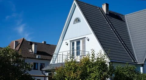 A private house of two floors with triangular roof and an area near the house Stock Photos
