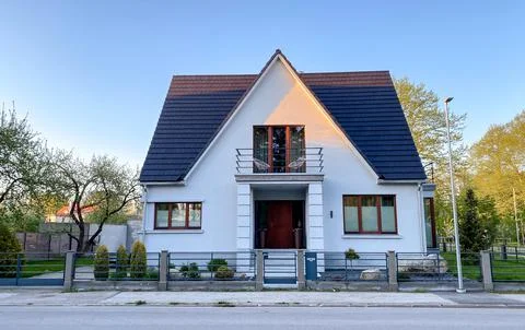 A private house of two floors with triangular roof and an area near the house Stock Photos