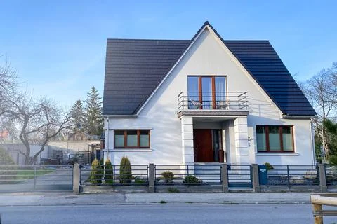 A private house of two floors with triangular roof and an area near the house Stock Photos