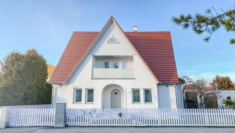 A private house of two floors with triangular roof and an area near the house Stock Photos