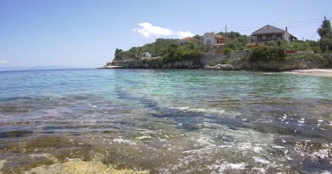 Private houses which is reflected in the blue waves of the Ionian Sea Stock Footage 63276441