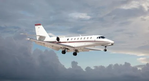 Private jet in the air with clouds in the background Foto stock