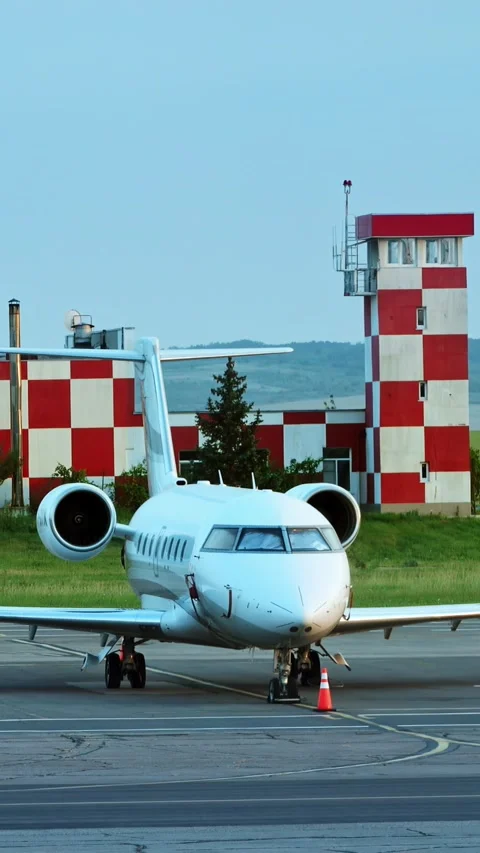Private jet at airport with control tower in background, white business air.. Stock Footage 339342510