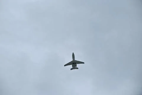 Private Jet Climbing After Takeoff into Overcast Cloudy Sky, Low Angle View Stock Photos