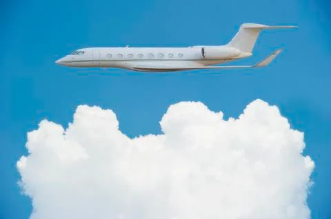 Private jet with fluffy clouds Stock Photos