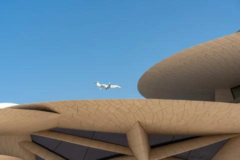 Private jet flying over interlocking discs of desert rose architecture at NMOQ. Stock Photos