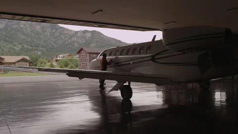 Private Jet Plane parked in Hanger, Pilot Walks Out - 3840 x 2160 Stock Footage 221451002