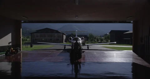 Private Jet Plane Tractor Tug out of Hanger - 5120 x 2700 Stock Footage 221037113