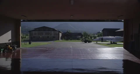 Private Jet Plane Tractor Tug into Hanger 2 - 5120 x 2700 Stock Footage 221272865