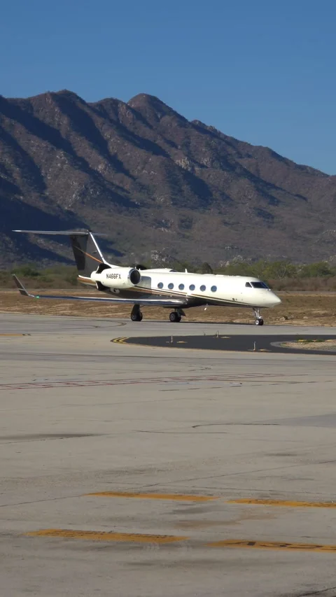 Private jet on tarmac with mountains in background Stock Footage 312517637