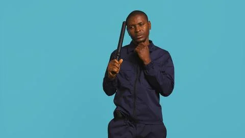 Private law enforcement worker cautioning trespassers with truncheon Stock Photos