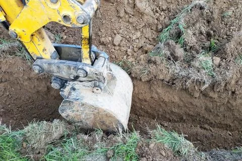 In a private plot, the excavator digs a trench. Stock-Fotos
