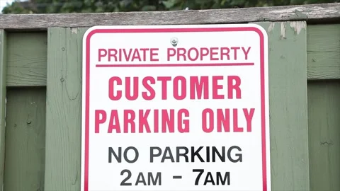 Private property customer parking only no parking 2am to 7am on green wood fence Vídeo Stock 249752344