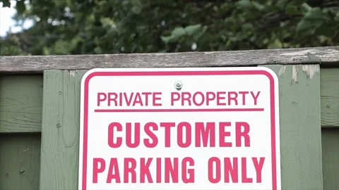 Private property customer parking only on green wood picket fence with blowing Stock Footage 249752406