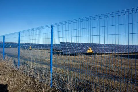 Private Solar panel field behind a protective fence Stock Photos