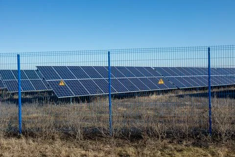 Private Solar panel field behind a protective fence Stock Photos