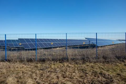 Private Solar panel field behind a protective fence Stock Photos