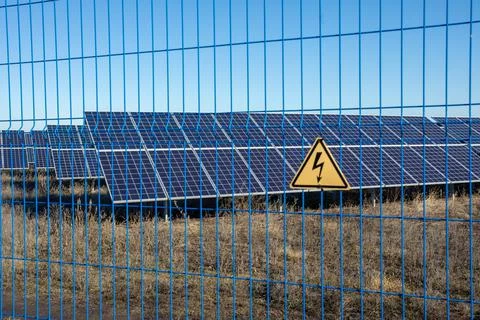 Private Solar panel field behind a protective fence Stock Photos