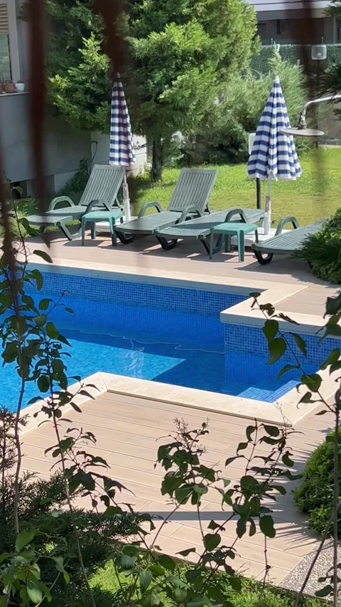Private swimming pool with tanning beds around Stock Footage 337199619