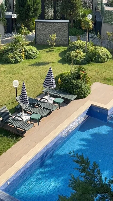 Private swimming pool with tanning beds around in a private villa Stock Footage 337203541