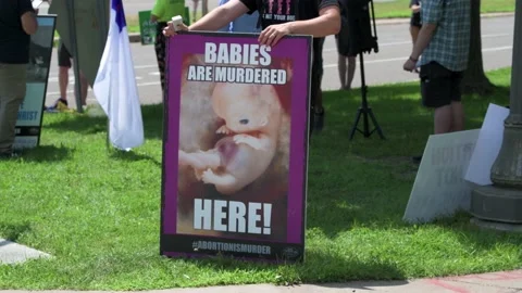 Pro abortion protesters hold up signs in front of anti-abortion protesters Video stock 201954177