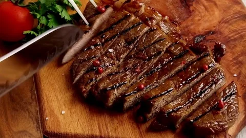 A pro chef slices a perfectly grilled steak, showing precision in every cut. 库存影片 336581592