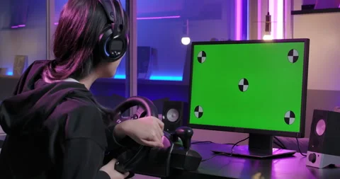 Pro gamer in simulator steering wheel playing with green chroma key monitor. Stock Footage 133866018