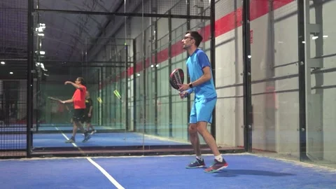 Pro padel player hit padel tennis ball in slow motion at idoor padel court. Stock Footage 265175975