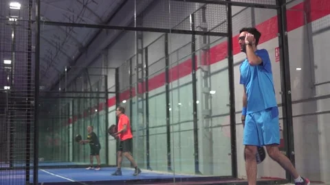 Pro padel player hit padel tennis ball in slow motion at idoor padel court. Vídeos de archivo 265176791