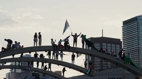 Pro Palestine Protesters waving flag on arch in Nathan Phillips Square, Stockbeeldmateriaal 231657808