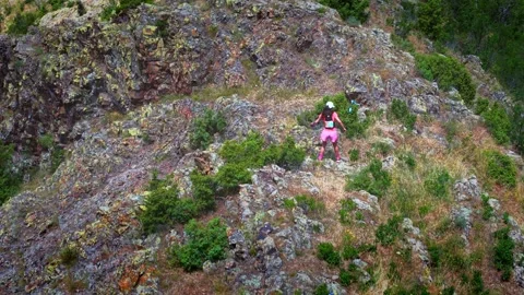 Pro runner climbing down a mountain from drone Stock Footage 317237069