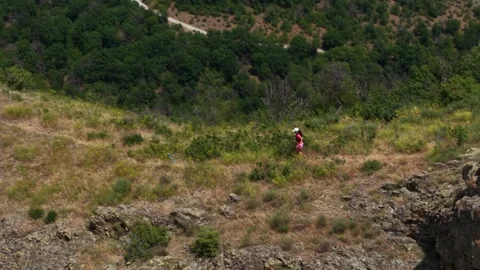 Pro runner climbing down a mountain 2 from drone Stock Footage 317237586