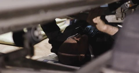 Pro surfer David Langer lying down and fixing broken engine of water jet ski Stock Footage 160586281