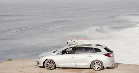 Pro surfer David Langer parking on edge of cliff with wavy ocean in background Stock Footage 164318193