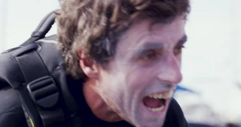 Pro surfer Sergio Cosme applying layer of sunscreen to his face and laughing Stock Footage 156624132