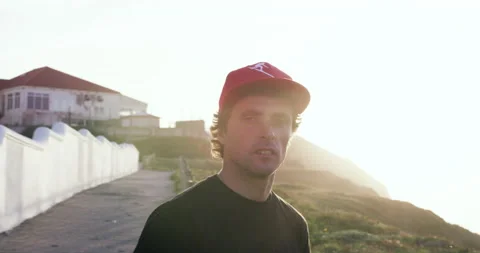 Pro surfer Sergio Cosme standing and watching view of Santa Cruz in slow motion Stock Footage 156282549