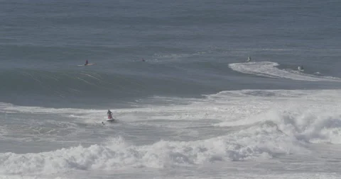 Pro surfers riding ocean waves on jet skis and surfboards on sunny day Stock Footage 160773670