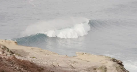 Pro surfers standing on edge of cliff next to car and watching wavy ocean Video stock 164319930