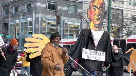 Pro-union speaker gesticulates in front of giant puppet of Amazon founder, Jeff Stock Footage 317688521