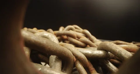 Probe lens pulling back from heap of rusty chains and anchor Stock Footage 165340332