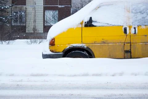 Problem after snowfall - snow on the city road, snow porridge. yellow car wit Stock Photos