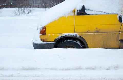 Problem after snowfall - snow on the city road, snow porridge. yellow car wit Stock Photos