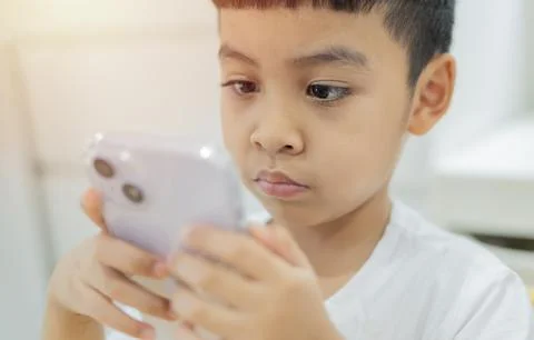Problem of children's addiction to gadgets, online, screen time. Asian litt.. Foto stock